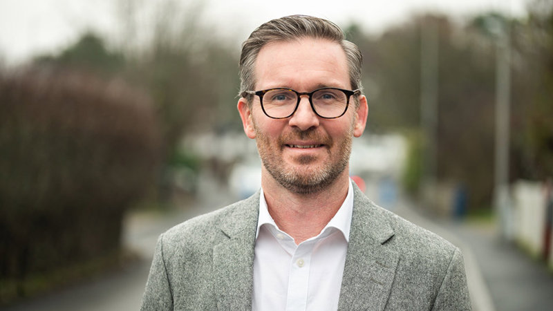 Foto på en man i vit skjorta och grå kavaj