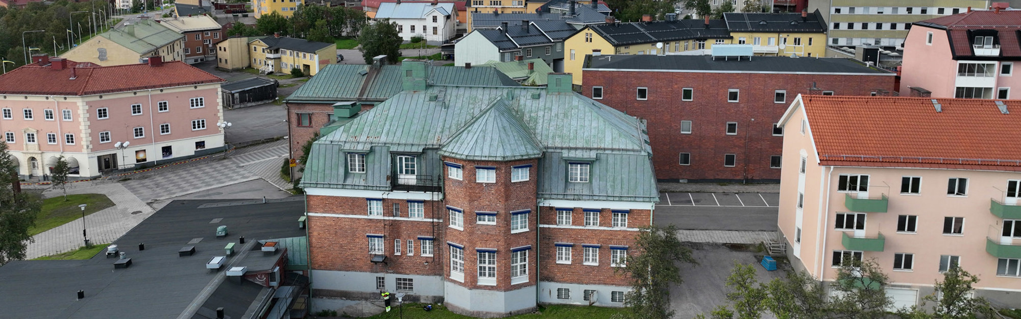 Luftbild av flera färgglada bostadshus med röda och gröna tak