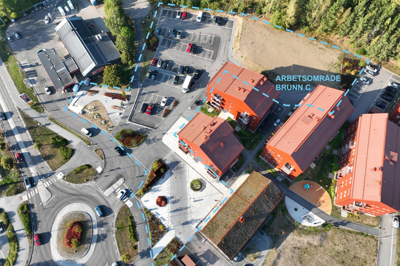 Luftbild med röda tak, parkeringsplatser och vägar.