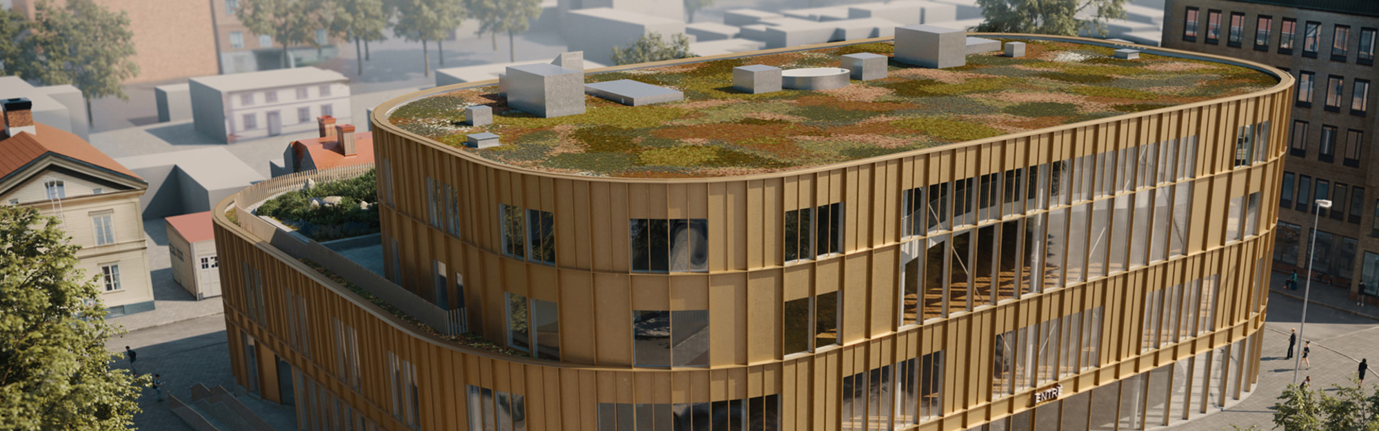 Modern byggnad med grönt tak och träfasad omgiven av andra hus.