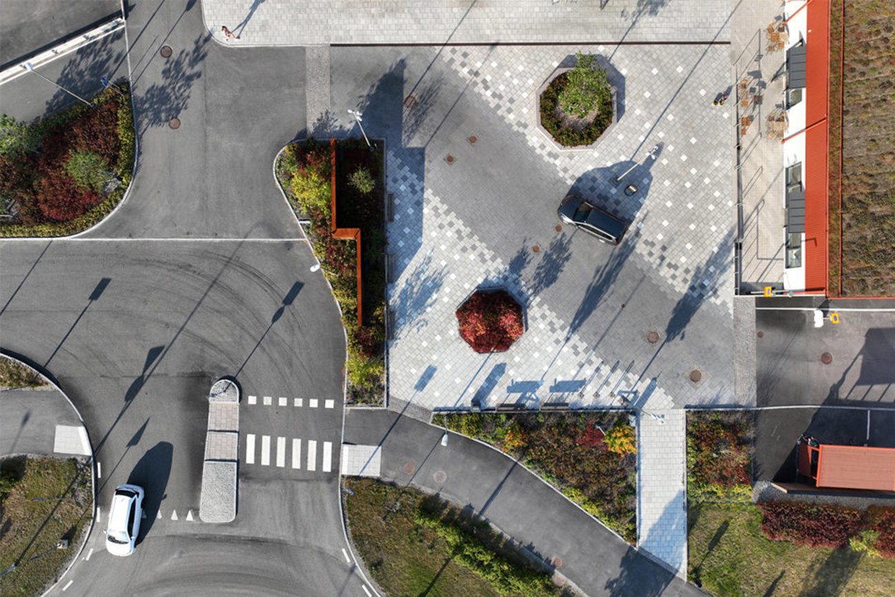 Luftbild av gatukorsning med vägar, övergångsställe, bilar och buskar.
